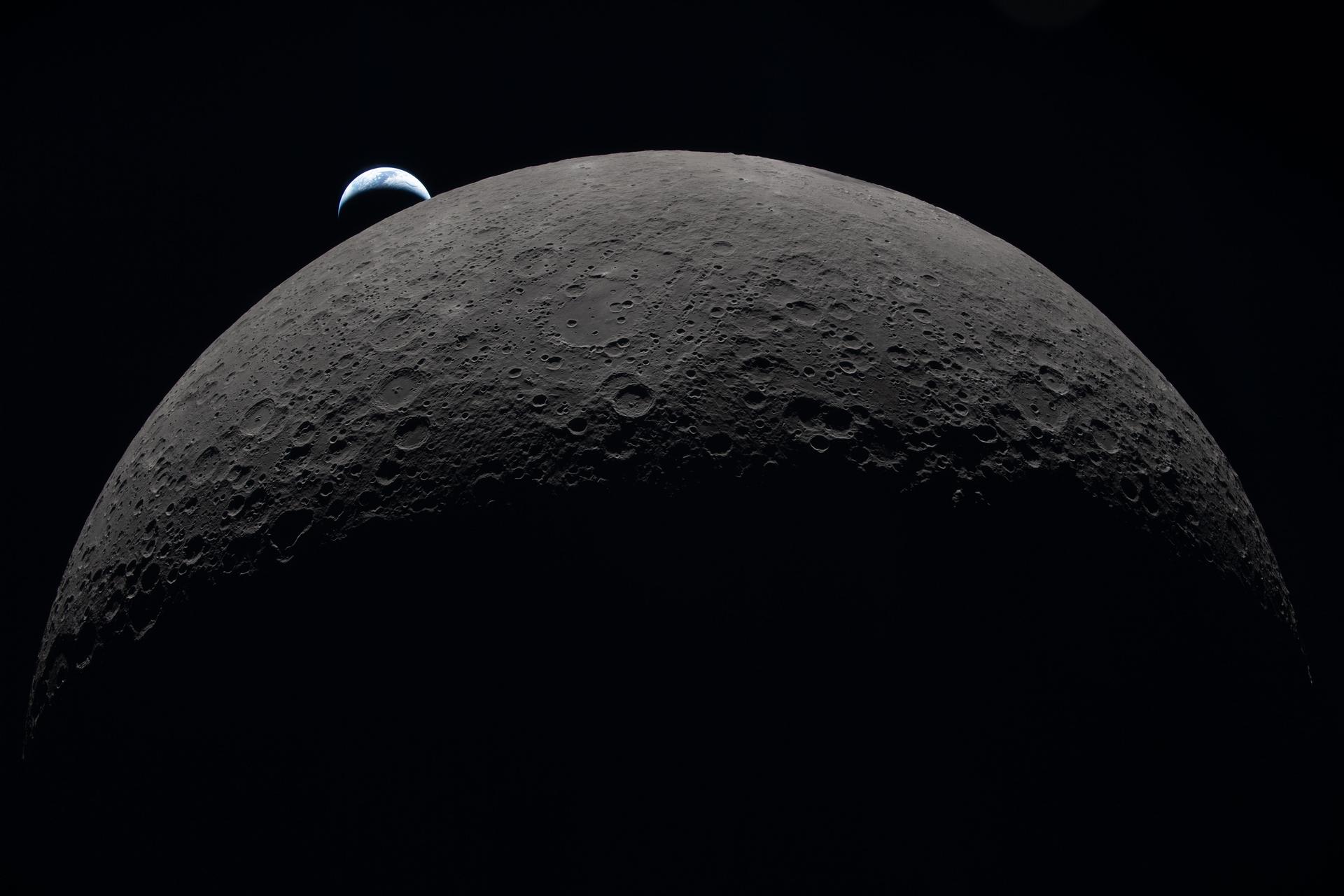 Earth rising above the Moon's cratered horizon, photographed by the Artemis II crew