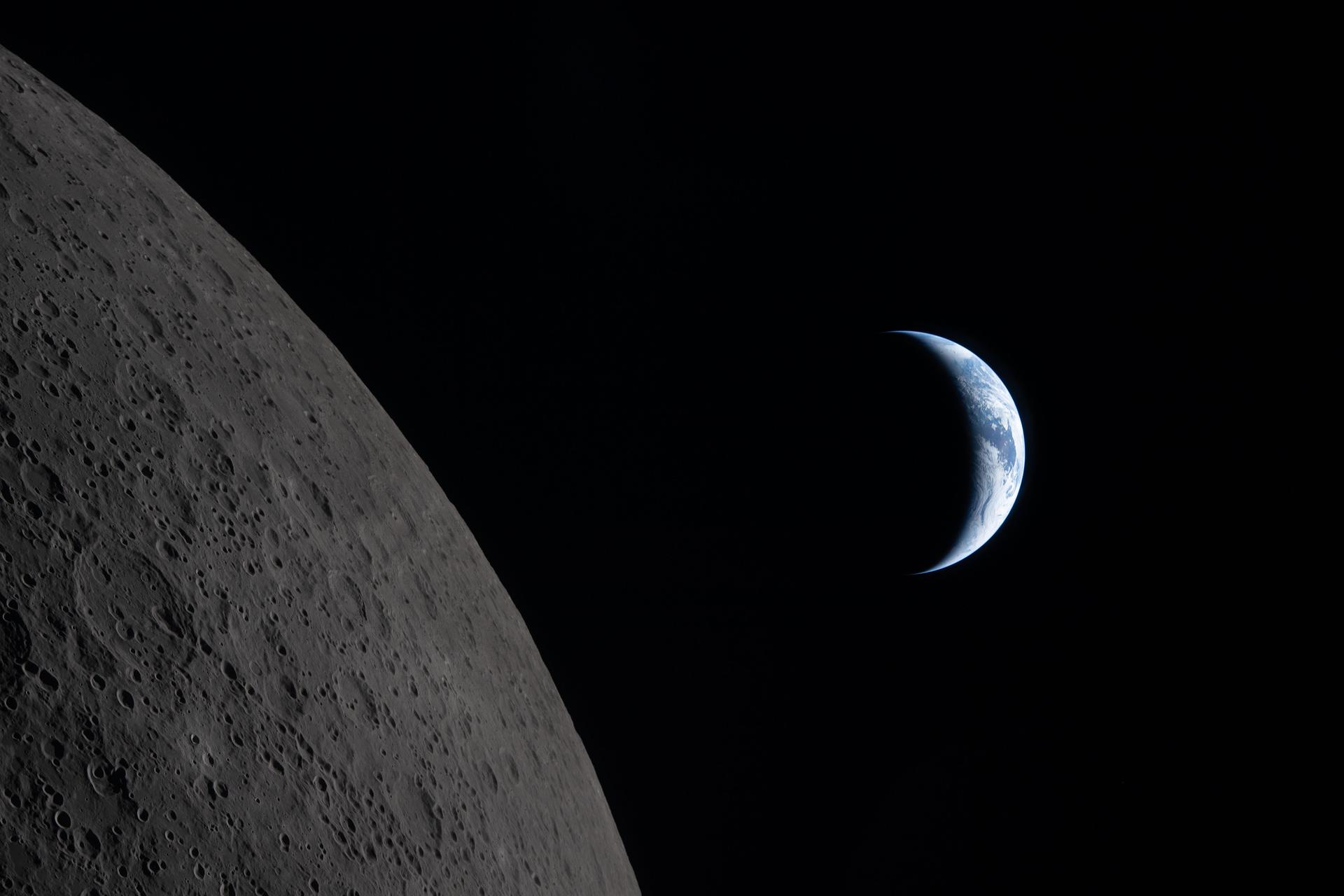 A crescent Earth visible beside the Moon's surface, photographed by the Artemis II crew